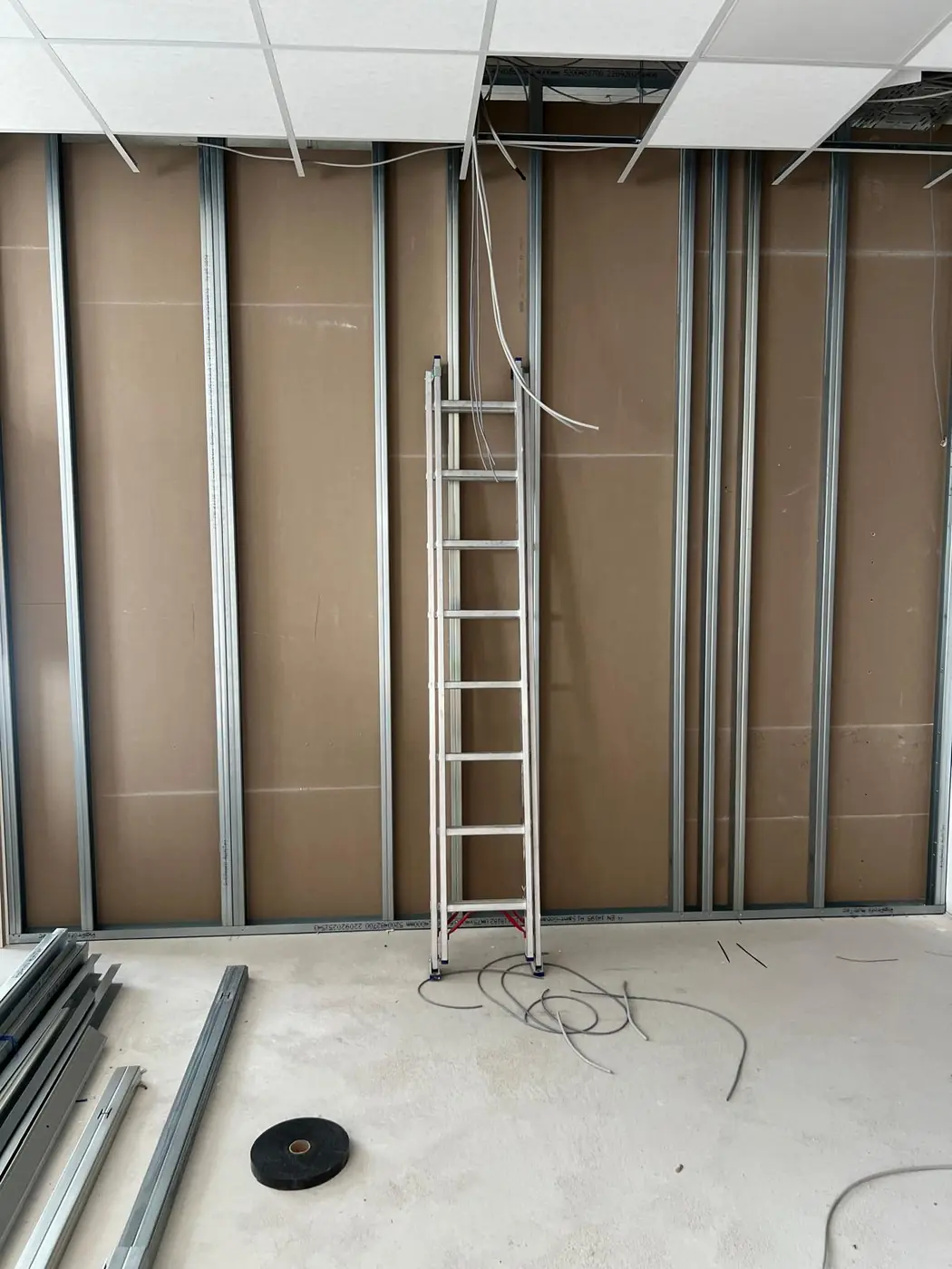 Metallständerwerk mit brauner Beplankung und abgehängter Rasterdecke auf einer Lidstein-Baustelle